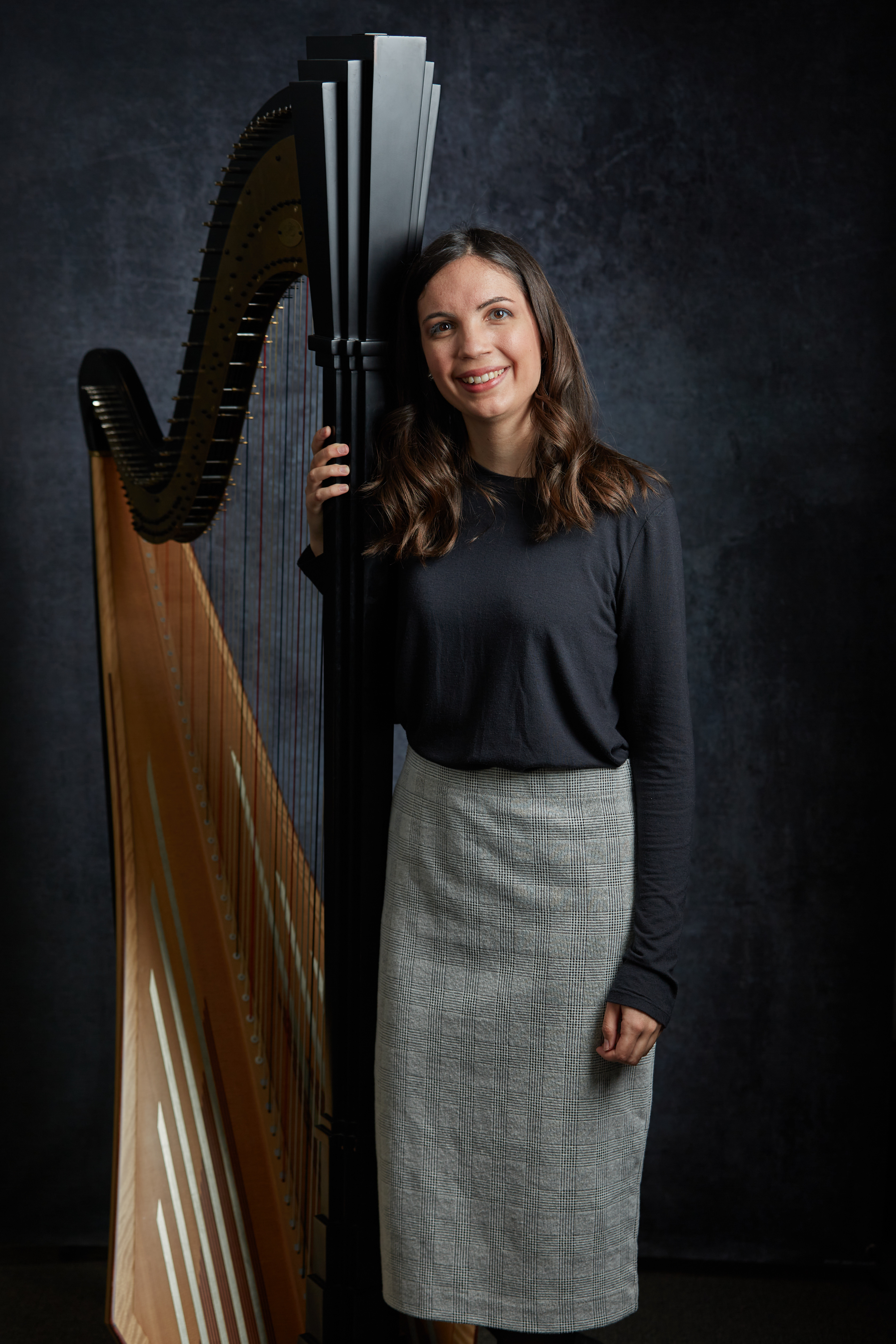 Brittany Blair posing next to a harp