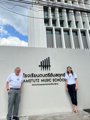 Peter Amstutz stands with the sign for the Amstutz Music School in Thailand