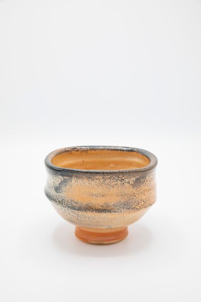 orange and black ceramic vessel