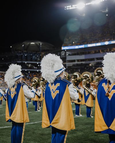 members of the 2022 WVU band perform during a night football game